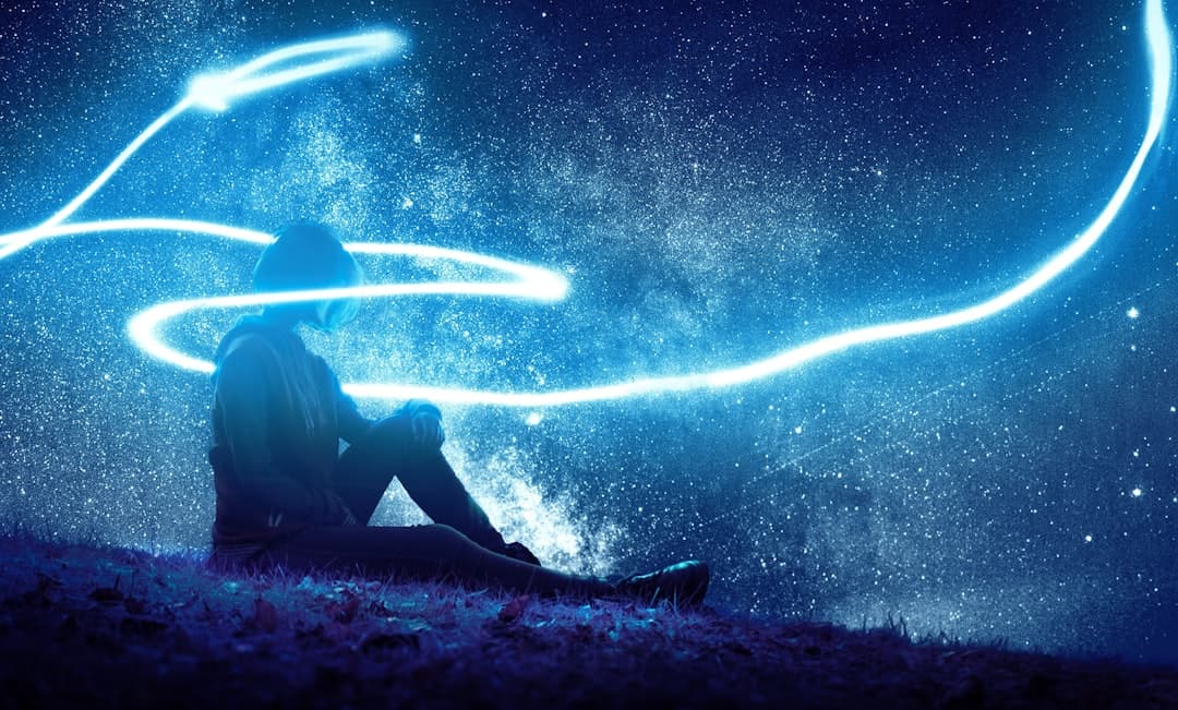 Paysage étoilé avec personne assise sous un ciel nocturne avec traînées lumineuses et voie lactée, image inspirante pour philosophie et réflexion, symbolise la quête de connaissance et la créativité intellectuelle.